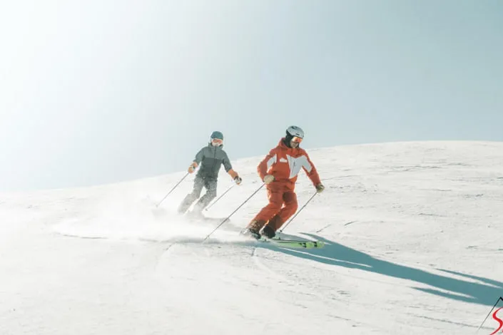 Two skiers on a snowy slope in Kirchberg
