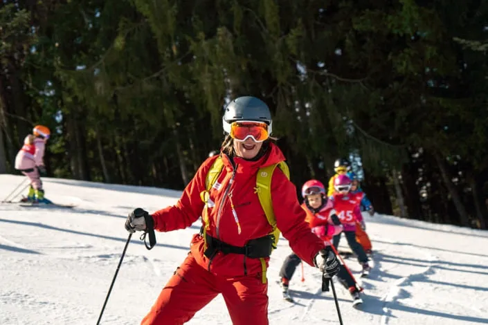 Ski instructor with students in the snow in Kirchberg