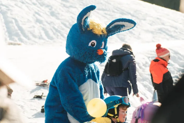 Blue bunny mascot on snowy terrain