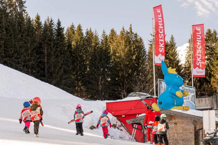 Children with skis at the ski school in Kirchberg