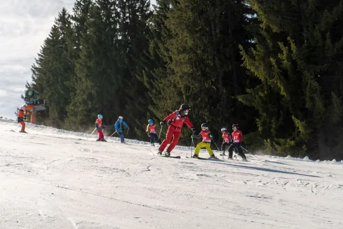 Children learning to ski with instructors in Kirchberg