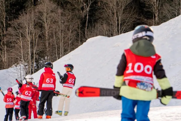 Ski students in Kirchberg, some wearing red vests