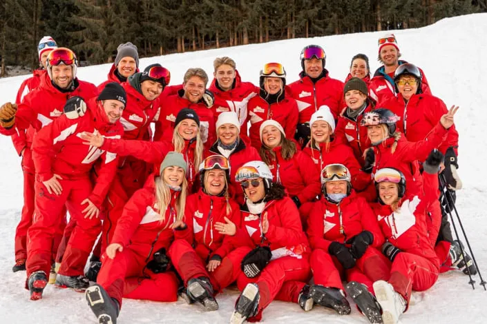 Group of skiers in red suits on the snow