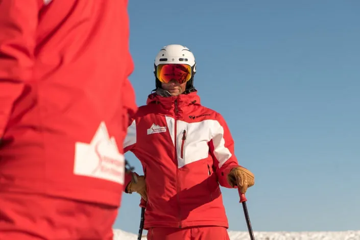 Ski instructors in red suits on snow.
