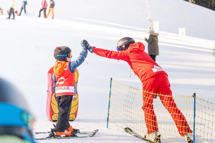 Child and ski instructor on the slope in Kirchberg